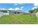 Large backyard with lush lawn, screened lanai, grill, and secure fencing for a private outdoor space at 242 Kings Pond Sw Ave, Winter Haven, FL 33880