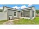 Landscaped backyard featuring a screened-in lanai, BBQ, and well-maintained lawn for outdoor enjoyment at 242 Kings Pond Sw Ave, Winter Haven, FL 33880