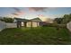 Spacious backyard featuring a screened-in lanai, well-kept lawn, privacy fence, and grilling area at 242 Kings Pond Sw Ave, Winter Haven, FL 33880