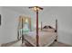 Bedroom with a four-poster bed, ceiling fan, and window overlooking a green yard at 242 Kings Pond Sw Ave, Winter Haven, FL 33880