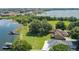 Aerial view showing a home on a lush green lawn near a lake and surrounded by trees at 254 Lake Tennessee Dr, Auburndale, FL 33823
