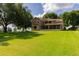 Spacious home with a large screened-in porch, surrounded by a well-maintained lawn and mature trees at 254 Lake Tennessee Dr, Auburndale, FL 33823