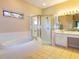 Bright bathroom featuring a soaking tub, glass shower, and vanity with a large mirror at 254 Lake Tennessee Dr, Auburndale, FL 33823
