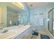 Charming light blue bathroom featuring double sinks, vanity, and tiled shower at 254 Lake Tennessee Dr, Auburndale, FL 33823