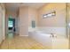The bathroom is complete with a tiled tub and a charming stained glass window at 254 Lake Tennessee Dr, Auburndale, FL 33823