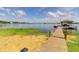 Private wooden dock featuring a covered boathouse on the calm lake at 254 Lake Tennessee Dr, Auburndale, FL 33823