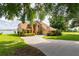 Stunning exterior view of a tan two-story home with a circular driveway and lush lawn at 254 Lake Tennessee Dr, Auburndale, FL 33823