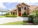 Attractive two-story home with a well-maintained lawn, spacious driveway, and a vibrant red front door at 254 Lake Tennessee Dr, Auburndale, FL 33823