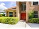 Charming home entrance featuring a vibrant red door and well-maintained landscaping at 254 Lake Tennessee Dr, Auburndale, FL 33823