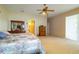 Spacious main bedroom featuring a large bed, a ceiling fan, and connecting entry to the main bathroom at 254 Lake Tennessee Dr, Auburndale, FL 33823