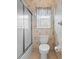 A bathroom featuring a toilet, window, and a glass enclosed shower/tub combo at 3341 Highland Fairways Blvd, Lakeland, FL 33810