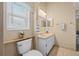 Bathroom featuring a window, a toilet, and a vanity with a mirror and lighting at 3341 Highland Fairways Blvd, Lakeland, FL 33810