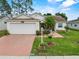Inviting single-story home featuring a lush green lawn, fresh landscaping, and a brick-colored driveway at 3341 Highland Fairways Blvd, Lakeland, FL 33810