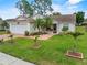Charming single-story home with a well-manicured lawn, mature palm trees, and lovely landscaping at 3341 Highland Fairways Blvd, Lakeland, FL 33810
