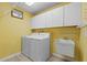 Convenient laundry room with storage cabinets, sink, washer and dryer at 3341 Highland Fairways Blvd, Lakeland, FL 33810