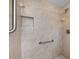 The tiled walk-in shower features a grab bar, shower niche, and updated fixtures at 3341 Highland Fairways Blvd, Lakeland, FL 33810