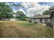 Spacious backyard with a grassy area, mature trees, and a partially fenced perimeter at 4008 S Carlisle Rd, Lakeland, FL 33813