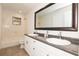 Bathroom featuring double sinks, granite countertops and framed mirrors and a tile shower at 4008 S Carlisle Rd, Lakeland, FL 33813