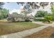 Charming single-story home with mature landscaping, a circular drive, and a blue front door at 4008 S Carlisle Rd, Lakeland, FL 33813