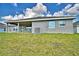 The backyard features a lush green lawn, a covered patio, and modern architectural details at 4023 Tullamore Ln, Auburndale, FL 33823