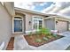 Close up of landscaped front entrance with a gray exterior, arched window and a blue front door at 4023 Tullamore Ln, Auburndale, FL 33823