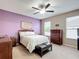 Cozy bedroom with ceiling fan, windows, and a wooden dresser with a decorative bed at 4041 Byrds Crossing Dr, Lakeland, FL 33812