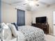 Well-lit bedroom boasts a ceiling fan, large television on wooden dresser, and patterned curtains at 4041 Byrds Crossing Dr, Lakeland, FL 33812