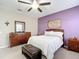 Cozy bedroom with ceiling fan, windows, and a wooden dresser with a decorative bed at 4041 Byrds Crossing Dr, Lakeland, FL 33812