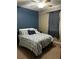 Comfortable bedroom featuring blue accent wall, a bed with patterned bedding, and natural light at 4041 Byrds Crossing Dr, Lakeland, FL 33812