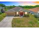 Charming single-story home featuring a well-maintained lawn, two-car garage, and a welcoming red double-door entrance at 4041 Byrds Crossing Dr, Lakeland, FL 33812