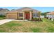 Well-maintained single-Gathering home featuring a manicured lawn, a two-car garage, and striking red front doors at 4041 Byrds Crossing Dr, Lakeland, FL 33812
