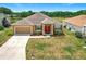 Charming single-story home featuring a well-maintained lawn, two-car garage, and a welcoming red double-door entrance at 4041 Byrds Crossing Dr, Lakeland, FL 33812