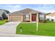 Charming one-story home with a well-manicured lawn, attached garage, and inviting red front door at 4041 Byrds Crossing Dr, Lakeland, FL 33812
