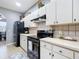 Well-lit kitchen with white cabinets, black appliances, and a large black refrigerator at 4041 Byrds Crossing Dr, Lakeland, FL 33812