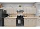 Charming kitchen features sleek black appliances, tiled backsplash, and white cabinetry at 4041 Byrds Crossing Dr, Lakeland, FL 33812