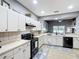 Modern kitchen with white cabinets, black appliances, and a decorative backsplash at 4041 Byrds Crossing Dr, Lakeland, FL 33812