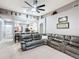 Open-concept living room features high ceilings, a ceiling fan, and an oversized leather couch at 4041 Byrds Crossing Dr, Lakeland, FL 33812