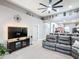 Open-concept living room features high ceilings, a ceiling fan, and an oversized leather couch at 4041 Byrds Crossing Dr, Lakeland, FL 33812