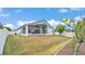 Expansive backyard with lush green grass, screened lanai and white fence at 412 Emerald Cove Loop, Lakeland, FL 33813