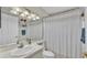 Bathroom with white vanity, mirror, shower with curtain and essential storage at 412 Emerald Cove Loop, Lakeland, FL 33813