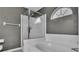 Bathroom with bathtub, glass shower, and an arched window at 412 Emerald Cove Loop, Lakeland, FL 33813