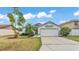 Charming single-story home with a two-car garage, palm tree, and neatly maintained lawn at 412 Emerald Cove Loop, Lakeland, FL 33813