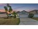 Well-maintained home features a manicured lawn, palm trees, and a two-car garage at 412 Emerald Cove Loop, Lakeland, FL 33813
