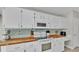 Bright kitchen featuring white cabinetry, butcher block countertops, and modern appliances at 412 Emerald Cove Loop, Lakeland, FL 33813