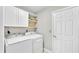 Convenient laundry room with washer, dryer, overhead cabinets and shelves at 412 Emerald Cove Loop, Lakeland, FL 33813