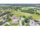 Aerial view of community amenities: pool, tennis courts, golf course, and green spaces for active lifestyle at 432 Sandestin Dr, Winter Haven, FL 33884