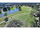 Panoramic aerial view of the golf course with a pond, lush landscaping and mature trees at 432 Sandestin Dr, Winter Haven, FL 33884