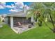 The screened-in patio area offers outdoor seating, a grill, and a lush green lawn with tropical landscaping at 432 Sandestin Dr, Winter Haven, FL 33884