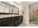 Granite countertop with and sinks, large mirror with Hollywood-style lighting, and walk-in shower at 432 Sandestin Dr, Winter Haven, FL 33884