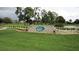 Community entrance sign surrounded by manicured lawns, lush landscaping and mature trees at 432 Sandestin Dr, Winter Haven, FL 33884
